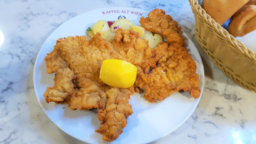 A large slice of schnitzel cooked to perfection, golden brown in colour, served with a small side of potato salad and bread rolls. Definitely one of the best foods to eat in Vienna. Not to mention one of the most traditional food in Austria you will find.