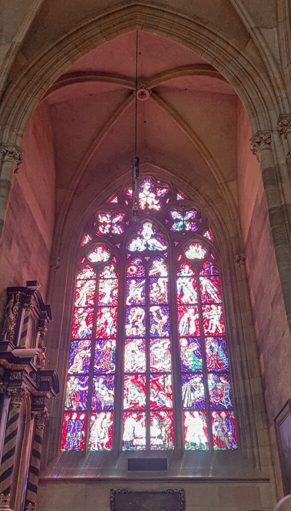 Light beaming through the beautiful stained glass window inside St Vitus Cathedral