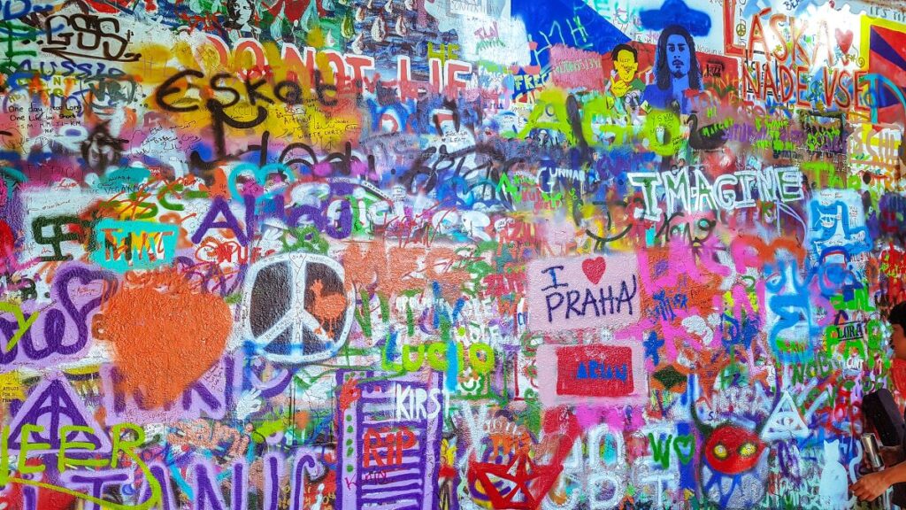 A colourful photo of the John Lennon wall filled with graffiti by locals and tourists that come to pay tribute to the singer/ songwriter.