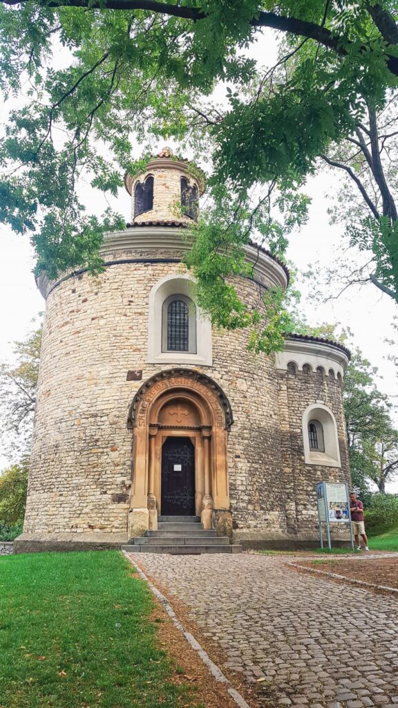 Brown concrete structure known as the rotunda sitting on the lawns surrounded by green trees