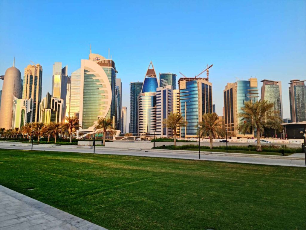 Skyline with tall concrete and glass buildings with a lawn and walkway infront of them