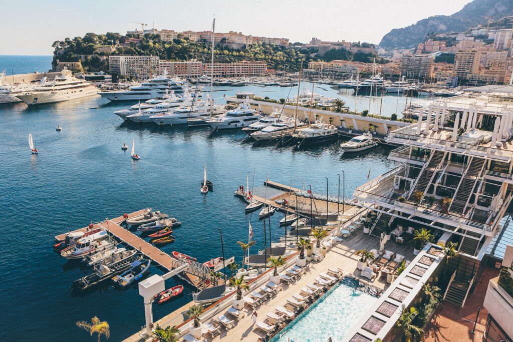 Ariel photo of docks with yachts and motorboats in pristine blue waters during daytime