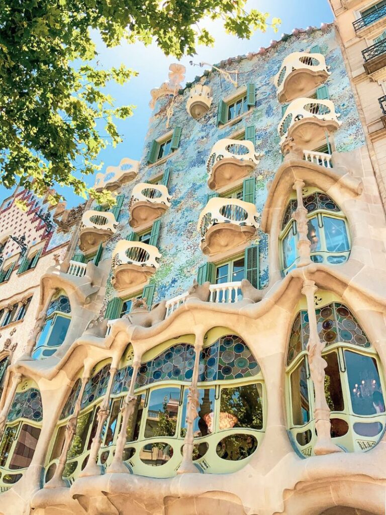 This photo shows the front façade of Casa Batlló. Covered with colorful mosaic and irregular oval glass windows.
