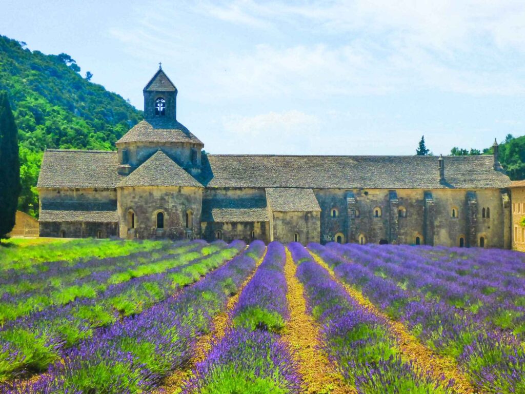 brown concrete building surrounded by lavender fields. One of the top places to visit in the south of france