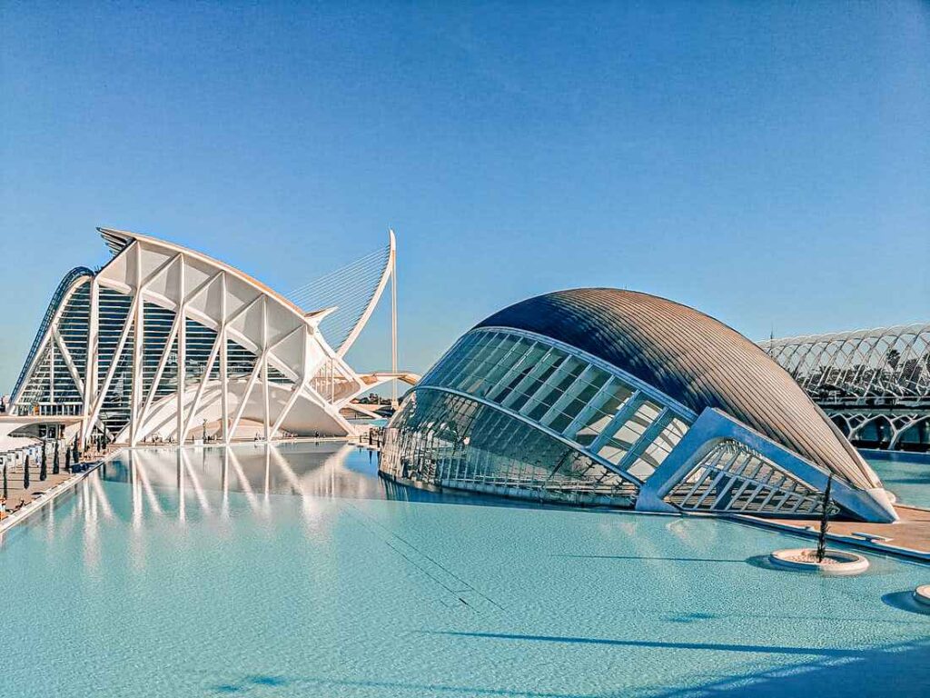 modern dome structure sitting on blue water during daytime