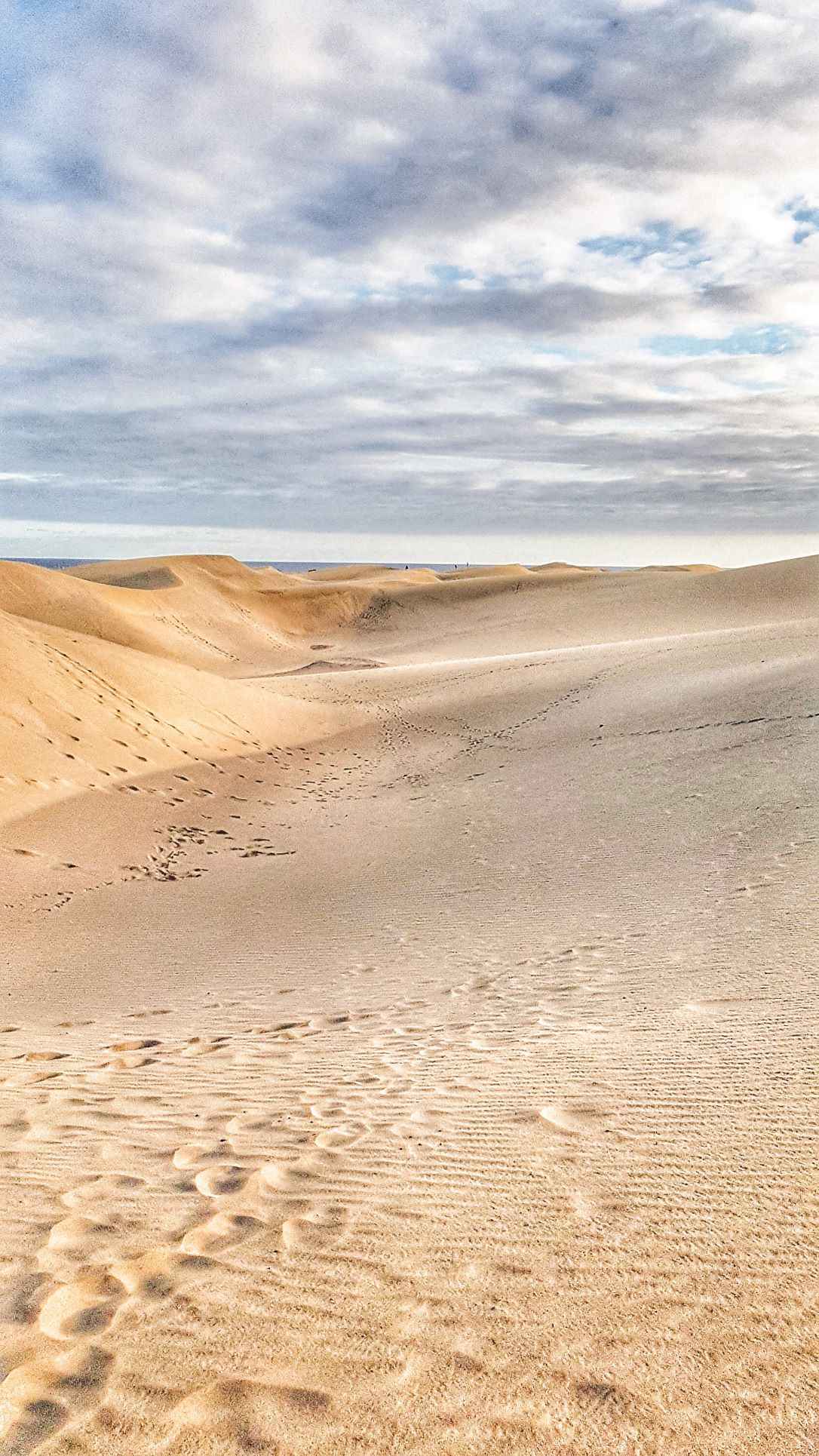 mountains of sand with the blue sea in a distance. one of the top tourist attractions in spain