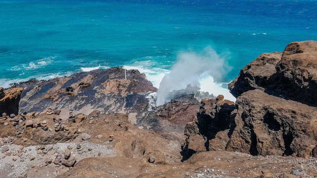 Brown rocks with a gush of water spurting out during daytime. one of the best free  places to visit in Oahu