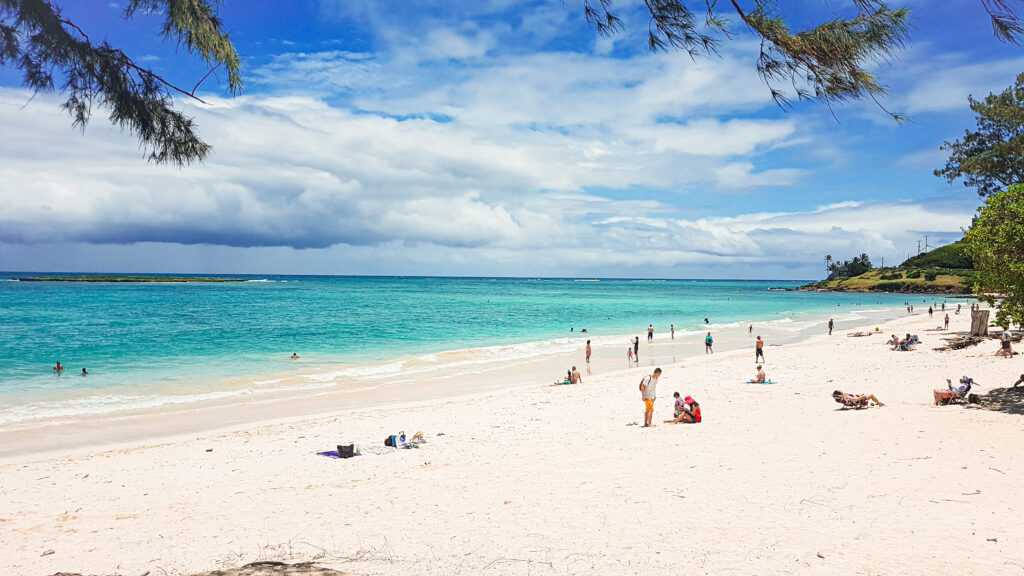 white sands, turquoise waters people sunbathing during daytime