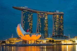 tall buildings near body of water during night time