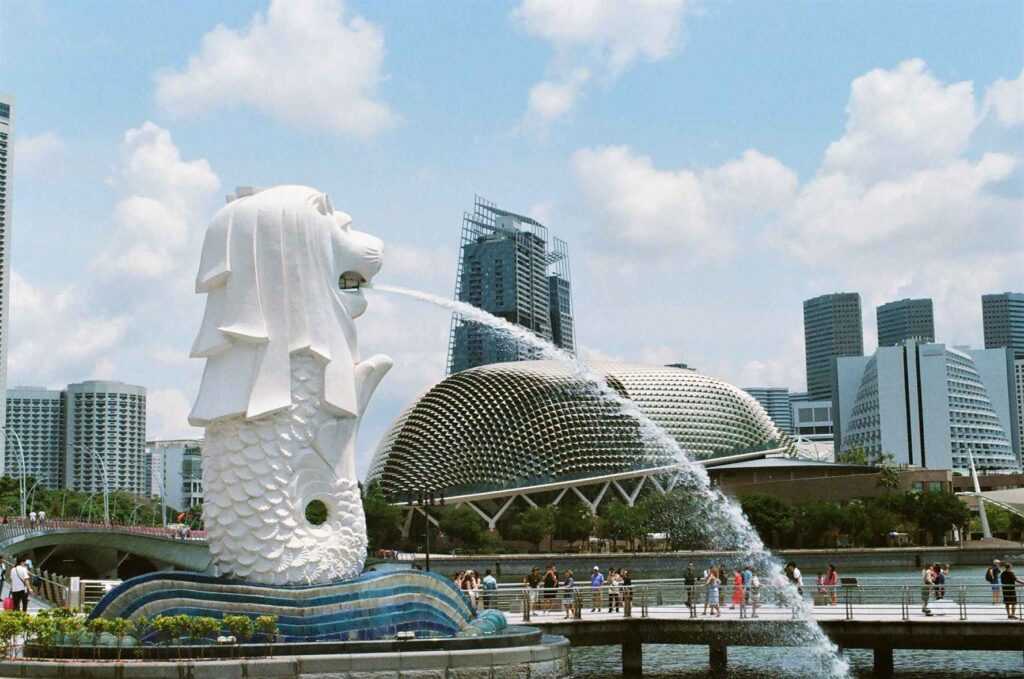 white concrete statue with lion head near buildings during daytime