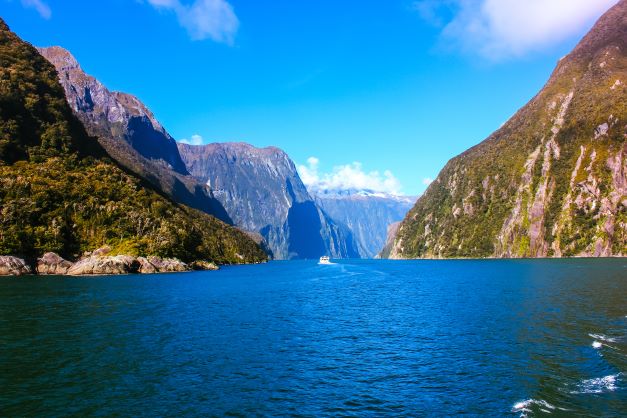 blue sea with brown mountains on either side. one of the top attractions in New Zealand