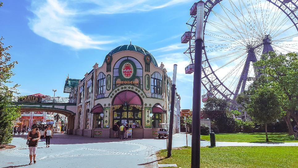 concrete structure with ferris wheel beside it during day time