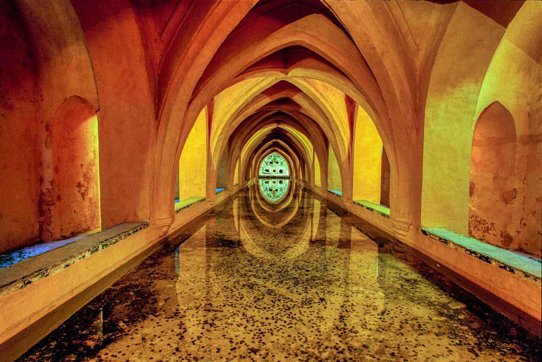 brown and beige tunnel with lights and water running through it