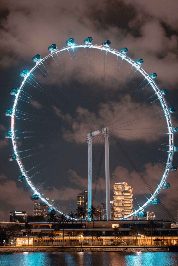 white and blue ferris wheel in the cityduring night time