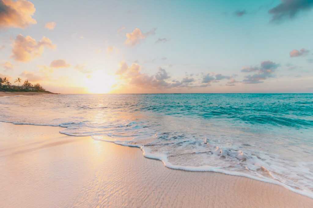 sunset on a beach during dusk. one of the best things to do in hawaii and top places to visit in oahu