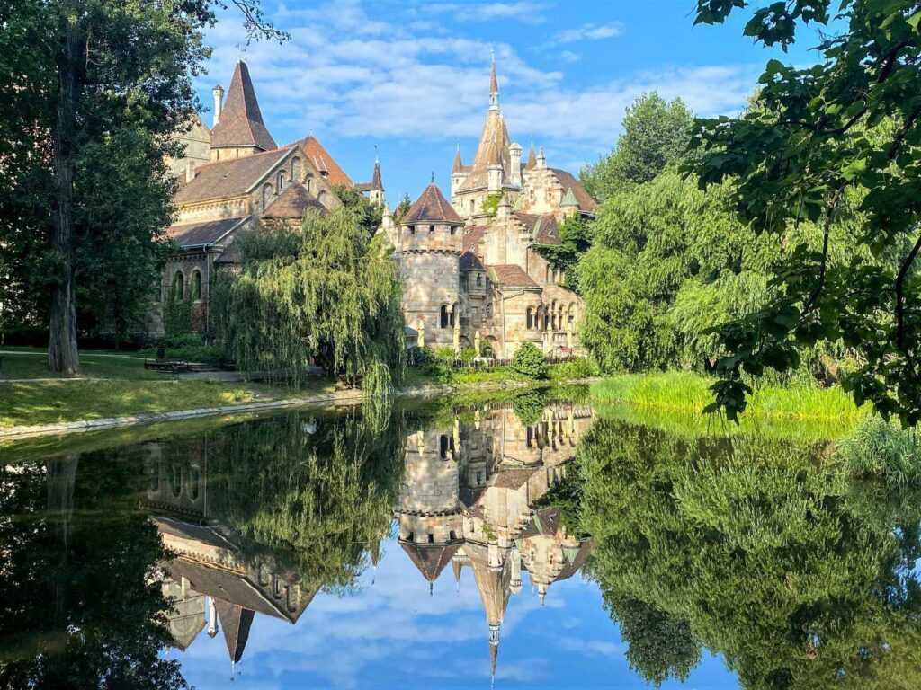 concrete castle building near a calm body of water during daytime