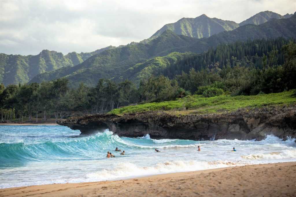 beach during day time with large waves. one of the top places to visit in Oahu.