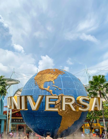 Round blue globe with gold map and the word universal on it during daytime