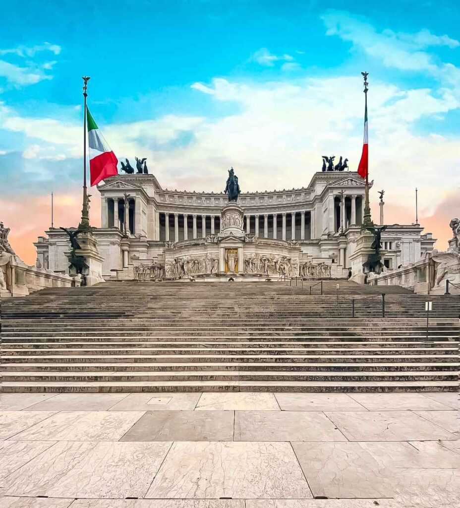 white concrete building with statues and flags during daytime