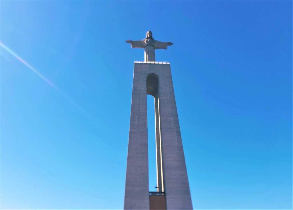 Tall concrete statue of Christ during day time