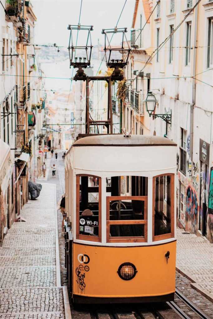 Yellow tram moving upslope during daytime