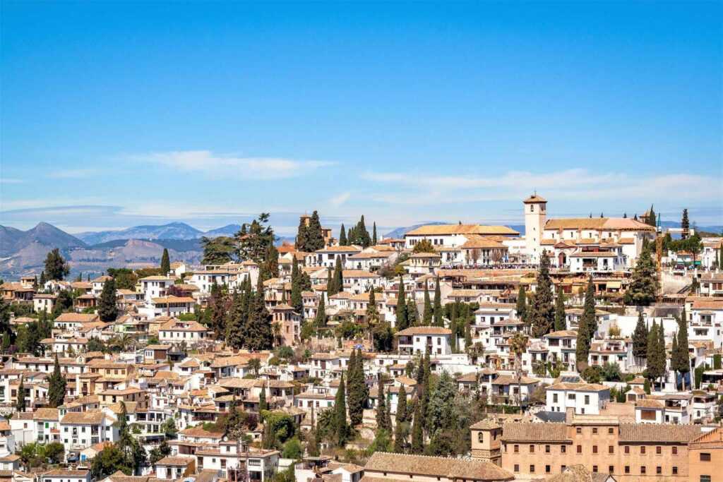 White concrete buildings with orange roof tops during daytime. Don't miss this place on your Southern Spain itinerary