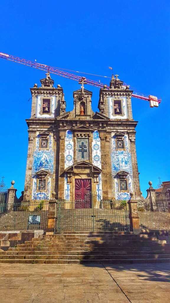 Old church covered in blue and white tiles sitting on a hill during daytime. Definitely a worthwhile place to visit in Porto