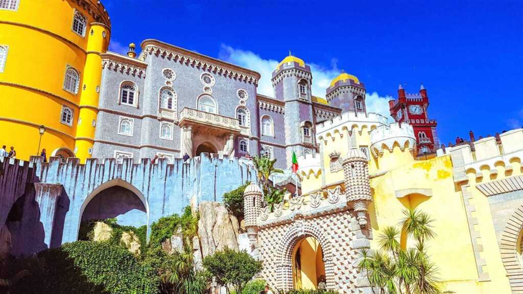 Colorful concrete structures surrounded by trees during daytime.  One of the most famous landmarks in Portugal