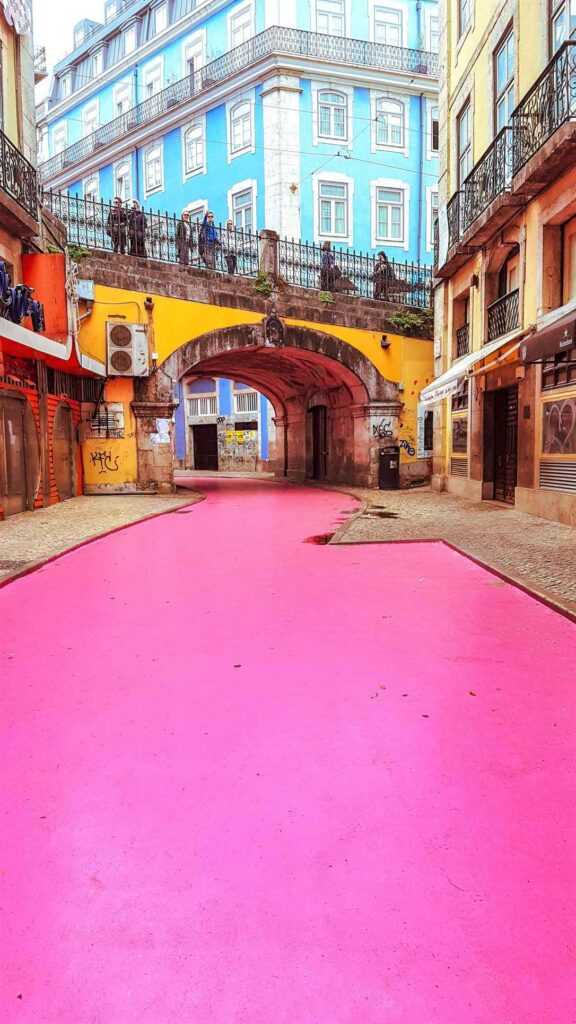 pink street under yellow bridge during daytime