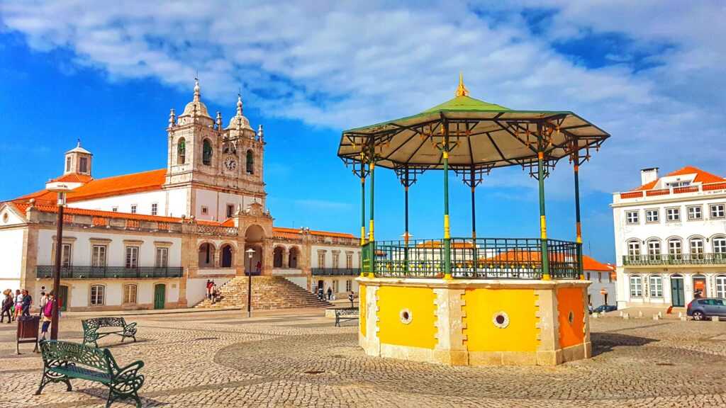 Yellow rotunda in the middle of a square surrounded by concrete structure 