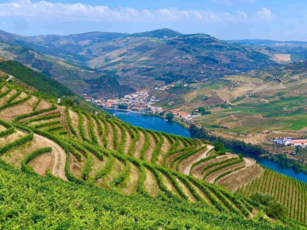 Green hills and valley with river running through it during daytime