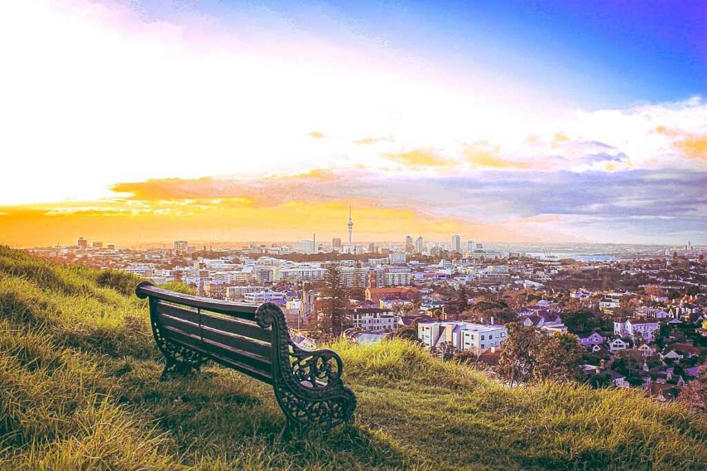 Bench on a hilltop overlooking view of the city during sunrise