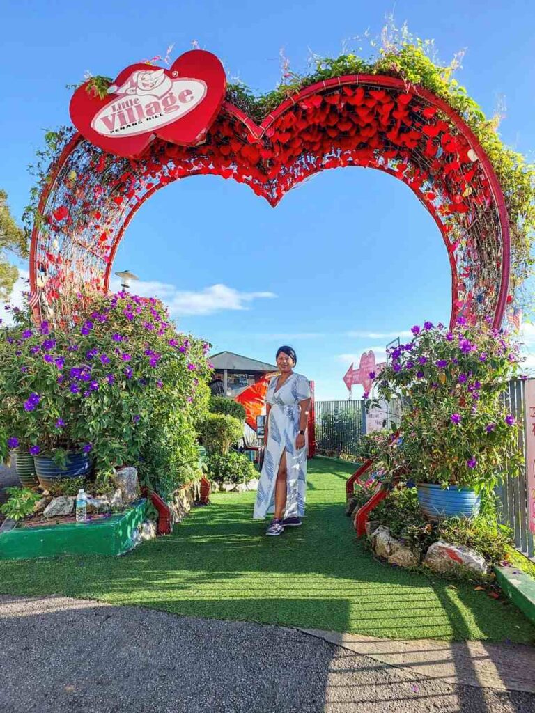 girl standing infront of heart frame during daytime