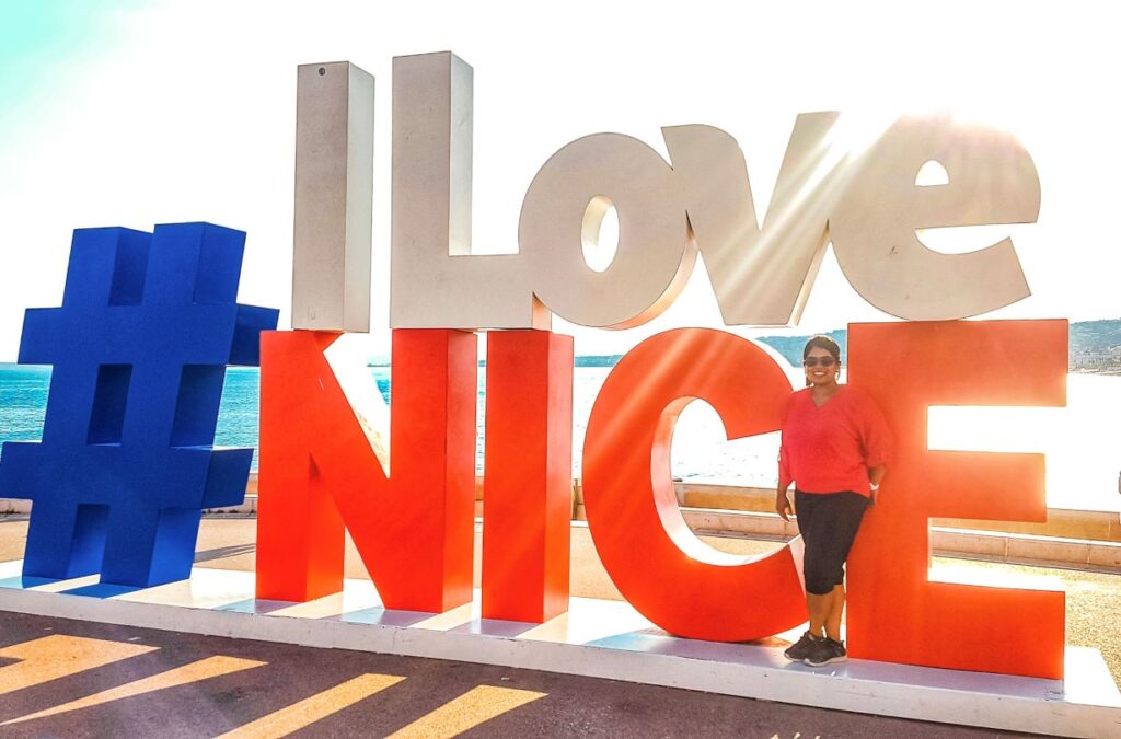 I Love Nice sign with girl standing in front of it