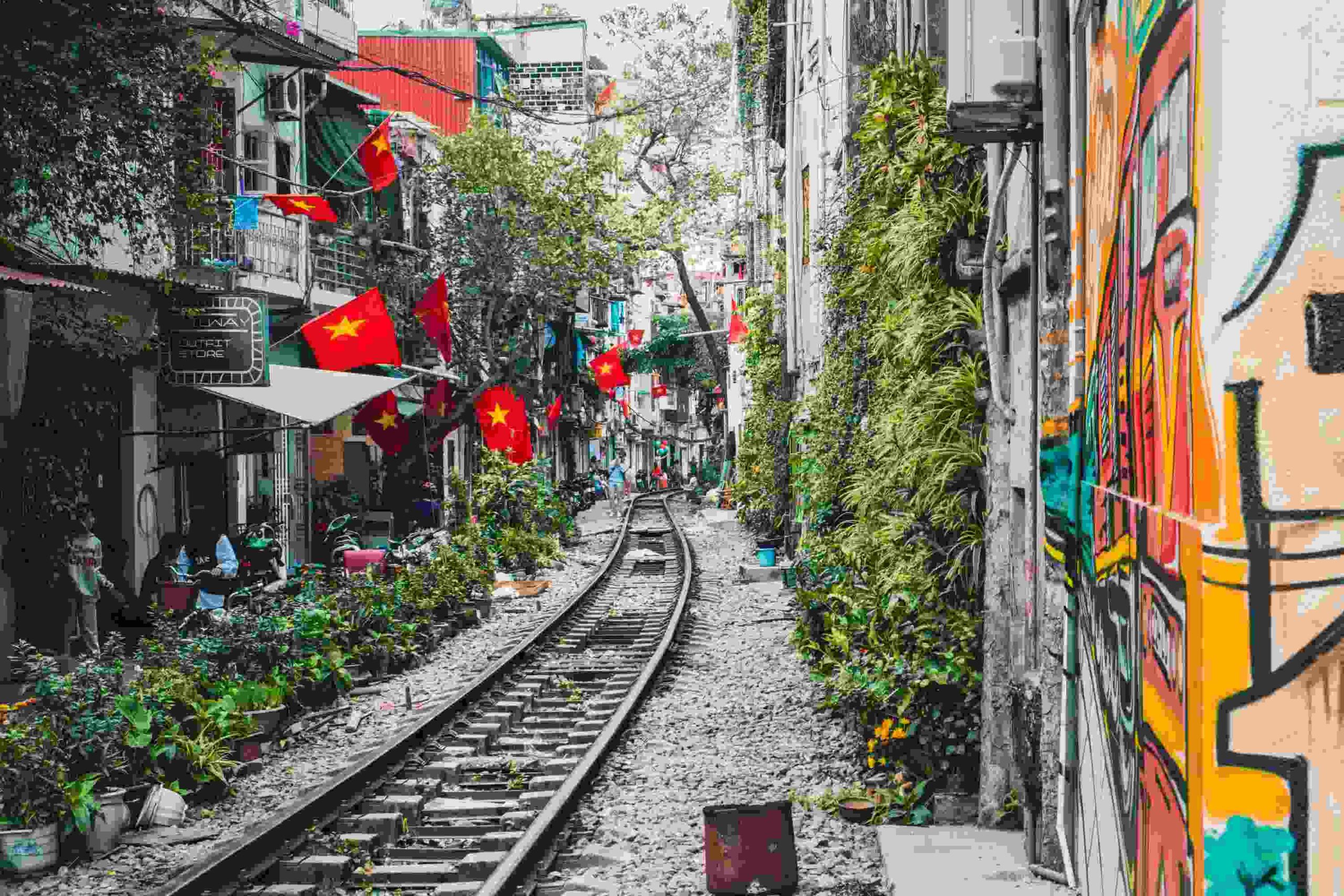 train tracks surrounded by colorful buildings and red flags