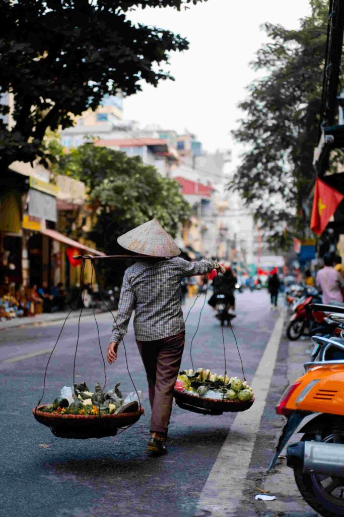 Person carrying a weight with baskets